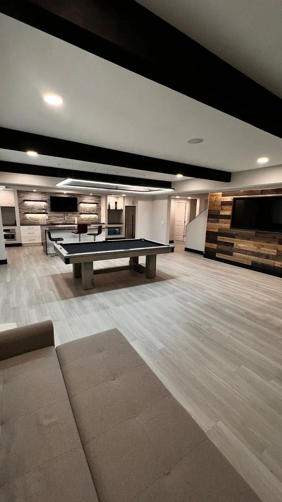 Finished basement entertainment room with bar and pool table