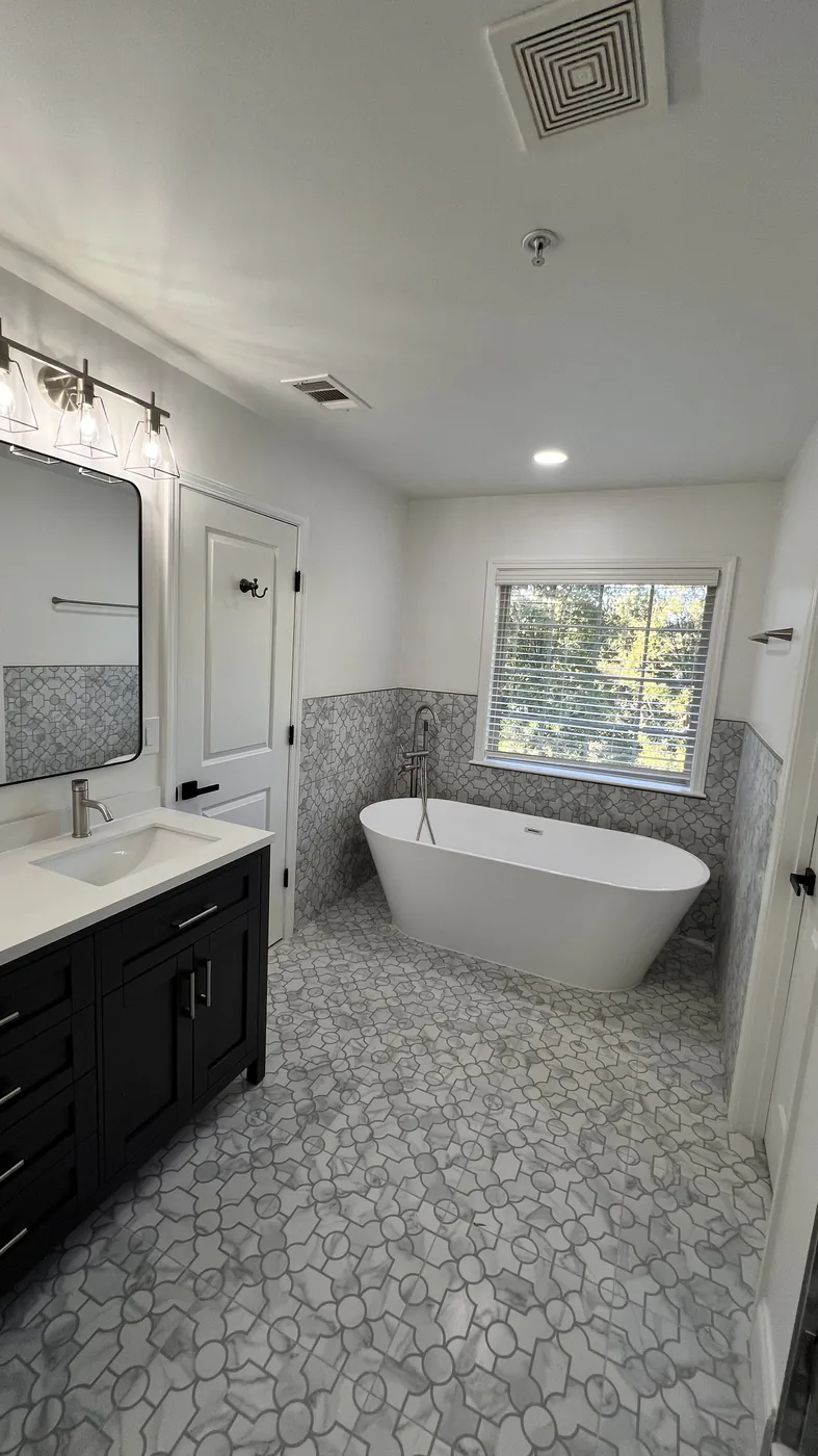 Completed bathroom with freestanding tub and patterned tile in Milton GA