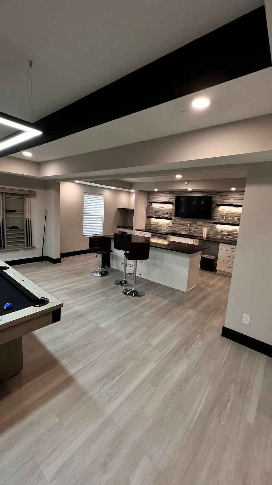 Open finished basement with modern bar, lighting and recreation area