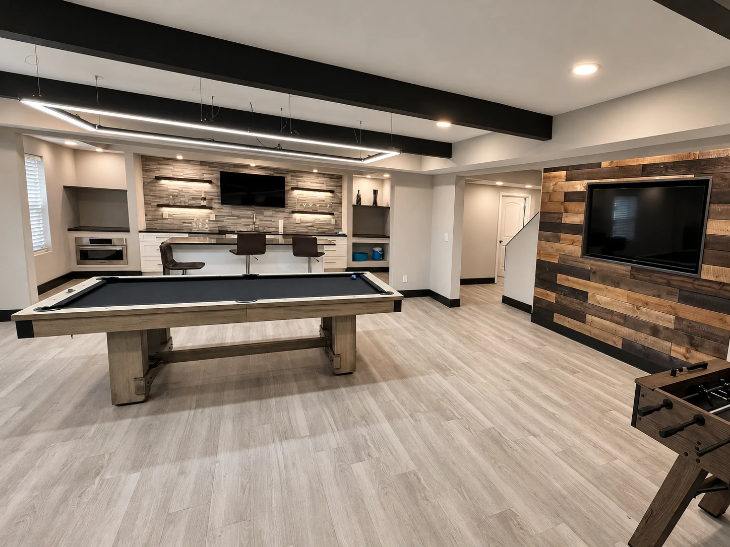 Finished basement recreation room with custom bar and modern lighting