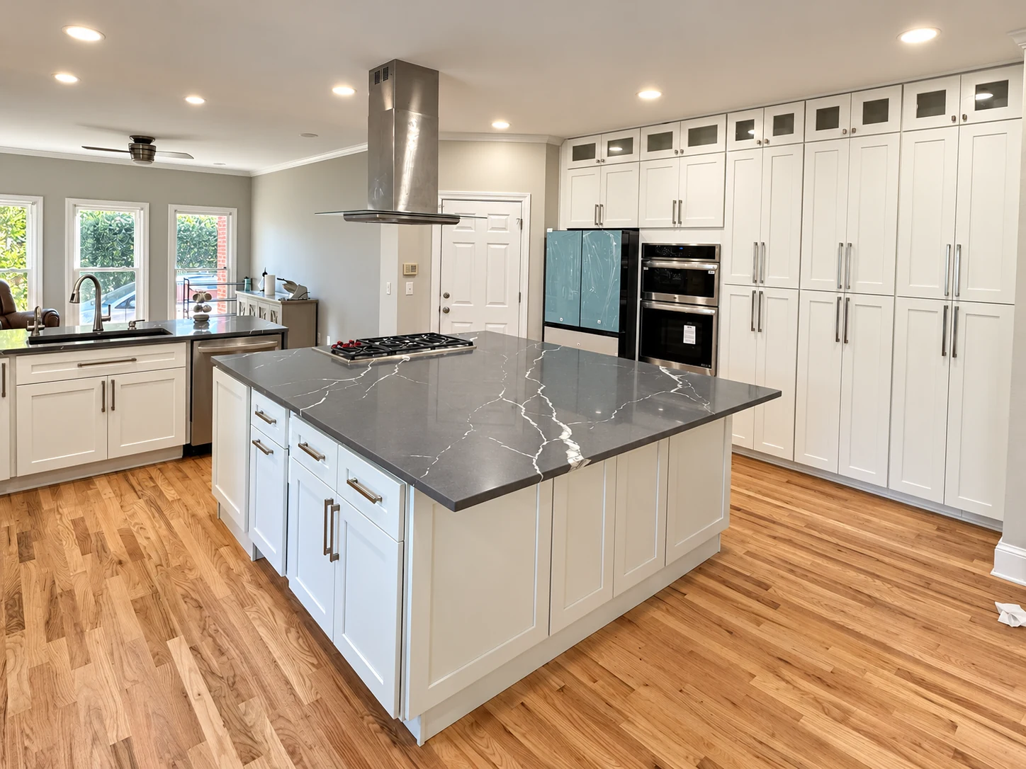 Completed kitchen remodel with dark island and custom cabinetry